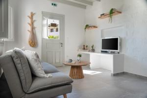 a living room with a chair and a tv at Limonletto in Patmos