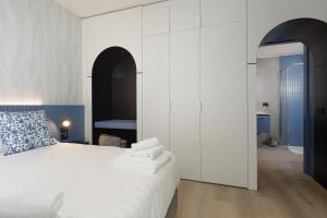 a bedroom with a white bed with a blue pillow at Palatium Riccione Suite in Riccione