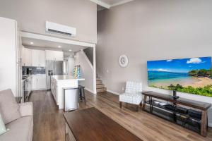 a living room with a large tv on a wall at 257 Hale Kamaole in Wailea