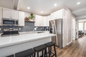 a kitchen with white cabinets and a stainless steel refrigerator at 257 Hale Kamaole in Wailea +17 photos