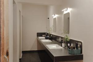 a bathroom with three sinks and two mirrors at Casa Antonio Mazunte in Mazunte