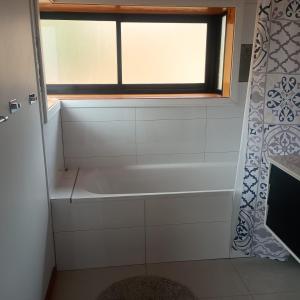 a bath tub in a bathroom with a window at Das Glashaus in Curacautín +20 photos