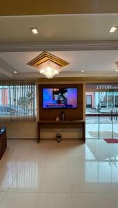 a lobby with a flat screen tv in a building at Domus Hotel Rio Verde - Parauapebas in Parauapebas +25 photos