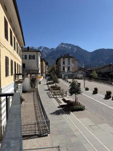 a city street with benches and buildings and mountains at Z&N Apartment in Levico Terme