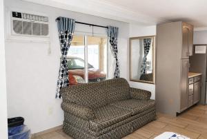 a living room with a couch and a window at Sunset Beach Hotel in Wildwood