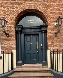 a blue front door of a brick building at EPIC Duke Street Townhouse, City Centre Apartments in Liverpool