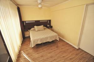 a bedroom with a bed and a ceiling fan at Hotel Costa Marfil Baquedano in Antofagasta