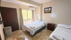 a bedroom with two beds and a window at NCG Suite in Guayaquil