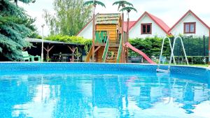 a house with a pool with a slide and a playground at Willa Opal , 250 m do morza in Grzybowo