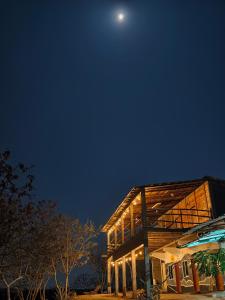 ein Haus bei Nacht mit dem Mond am Himmel in der Unterkunft El Cielo Hostel in Barra de la Cruz