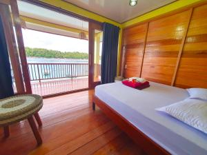 a bedroom with a bed and a large window at Santi Garden Bungalows in Iboih