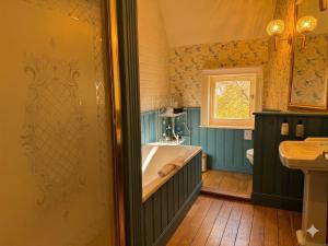 a bathroom with a tub and a sink at Le Manoir des Etangs in Etbos