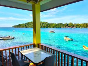 a balcony with a view of the water and boats at Santi Garden Bungalows in Iboih