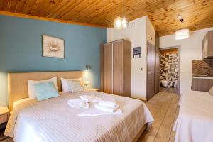 a bedroom with a large bed with towels on it at Studios Sotiria in Limenas +9 photos