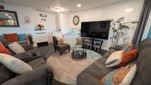 a living room with a couch and a tv at Waterfront Gem in Willingboro