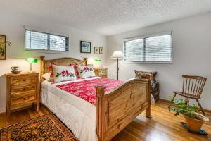a bedroom with a bed and a chair and two windows at Eclectic Multi-Level Charmer! 2 Mi to CU Boulder in Boulder