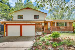 a house with two garage doors in a yard at Eclectic Multi-Level Charmer! 2 Mi to CU Boulder in Boulder
