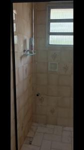 a shower with a glass door in a bathroom at Pousada da Lú in Jaguarão +59 photos