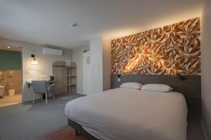 a bedroom with a bed with a painting on the wall at Sure Hotel by Best Western Nantes Saint-Herblain in Saint-Herblain +50 photos