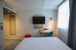 a bedroom with a bed and a table and a window at Sure Hotel by Best Western Nantes Saint-Herblain in Saint-Herblain