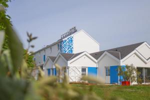 a large white building with blue accents at Sure Hotel by Best Western Nantes Saint-Herblain in Saint-Herblain