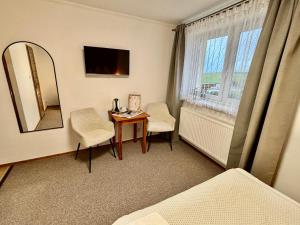 a room with a table and chairs and a mirror at Villa Slnecnica in Nová Lesná