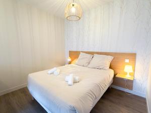 a bedroom with a bed with two towels on it at Volcania Suites in Clermont-Ferrand