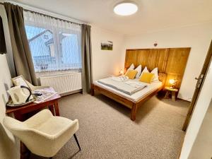 a hotel room with a bed and a chair and a window at Villa Slnecnica in Nová Lesná