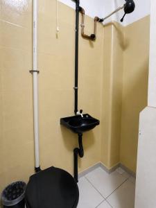 a bathroom with a black sink and a toilet at Solar Clefis in Vitória