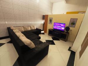 a living room with a couch and a tv at Diadema Studio - Apt 11 in Diadema