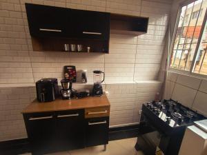 a kitchen with black cabinets and a stove top oven at Diadema Studio - Apt 11 in Diadema