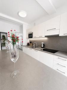 a white kitchen with a vase with red flowers in it at Dietro le Quinte Rho Apartments in Rho