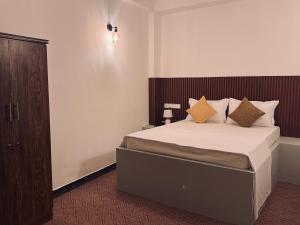 a bedroom with a large bed with a wooden headboard at New National in Pettah