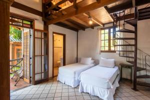 two beds in a room with a staircase at Pousada Villaggio Assis in Ilhabela +78 photos