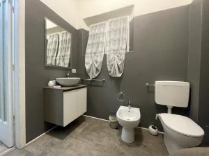 a bathroom with a toilet and a sink and a mirror at LA VIOLETTA DI PARMA // DEL DUCATO in Parma