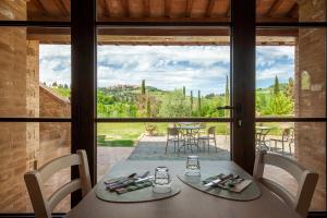 a dining room with a table and a large window at Agriturismo Marinello in Pienza