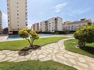 two trees in a park with buildings in the background at Sea&Kids in Malgrat de Mar