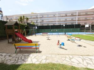 a playground with slides and play equipment in front of a building at Sea&Kids in Malgrat de Mar