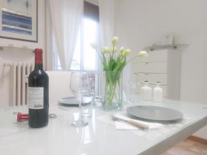 a bottle of wine sitting on a table with a glass at Milan Top-Floor Flat City View 2 Balconies Workspace M5 in Milan +17 photos