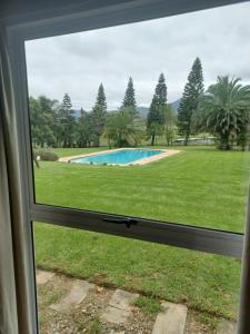 a window view of a yard with a swimming pool at Esperanza Wood Room in George