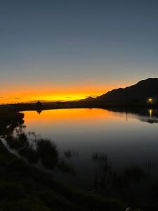 a sunset over a body of water with the sun setting at Esperanza Wood Room in George
