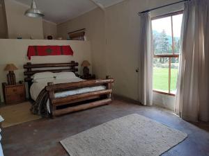 a bedroom with a bed and a large window at Esperanza Wood Room in George