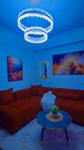 a living room with a red couch and a chandelier at CB Luxury in Kisii