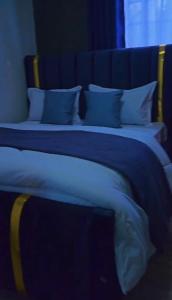two beds in a room with blue sheets and pillows at CB Luxury in Kisii