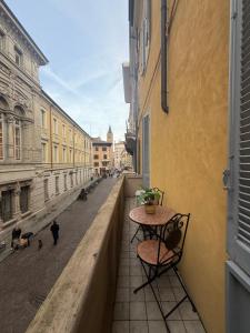 a table and chairs on a balcony with a street at LA VIOLETTA DI PARMA // DEL DUCATO in Parma