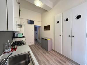 a kitchen with white cabinets and a sink at LA VIOLETTA DI PARMA // DEL DUCATO in Parma