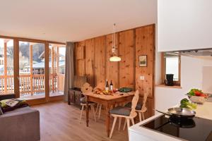 een keuken en eetkamer met een houten muur bij Residence Simml & Schlosser in San Candido