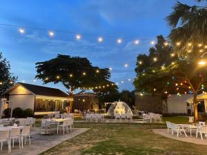 a marquee with white tables and chairs at night at The Canal Ratchaburi in Ratchaburi +109 photos