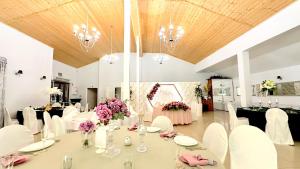 a banquet hall with white tables and chairs and flowers at Willa Opal , 250 m do morza in Grzybowo
