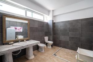 a bathroom with a sink and a mirror and a toilet at León Hotel Saranda in Sarandë +79 photos